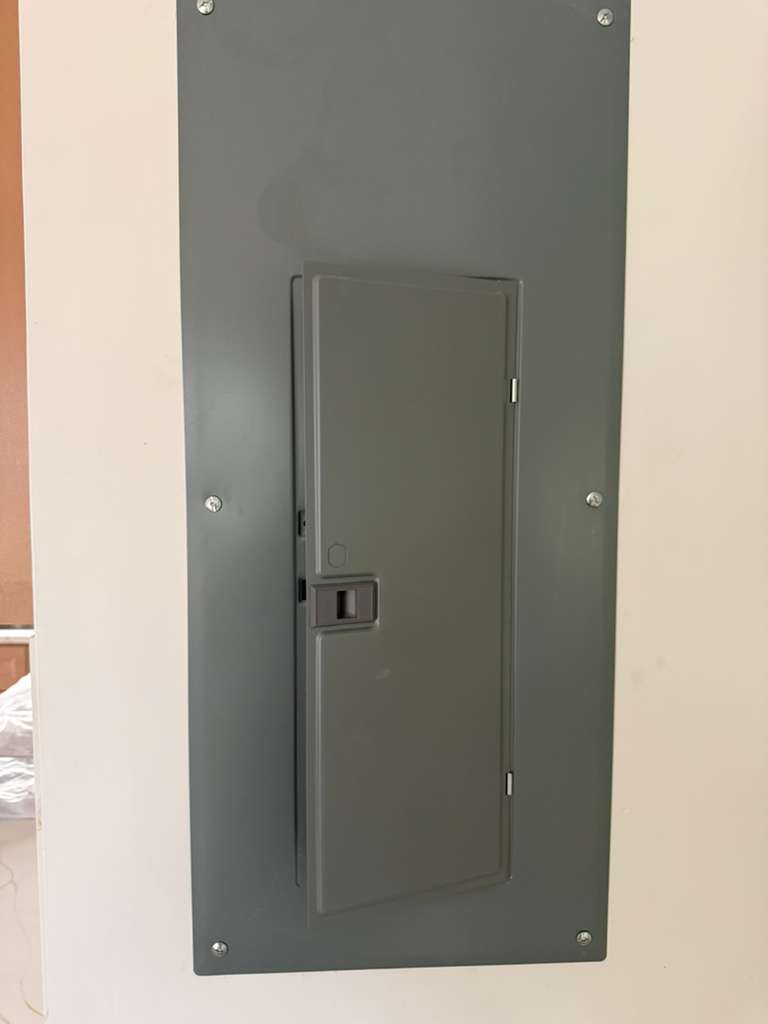 Electrical panel (closed) against a white wall