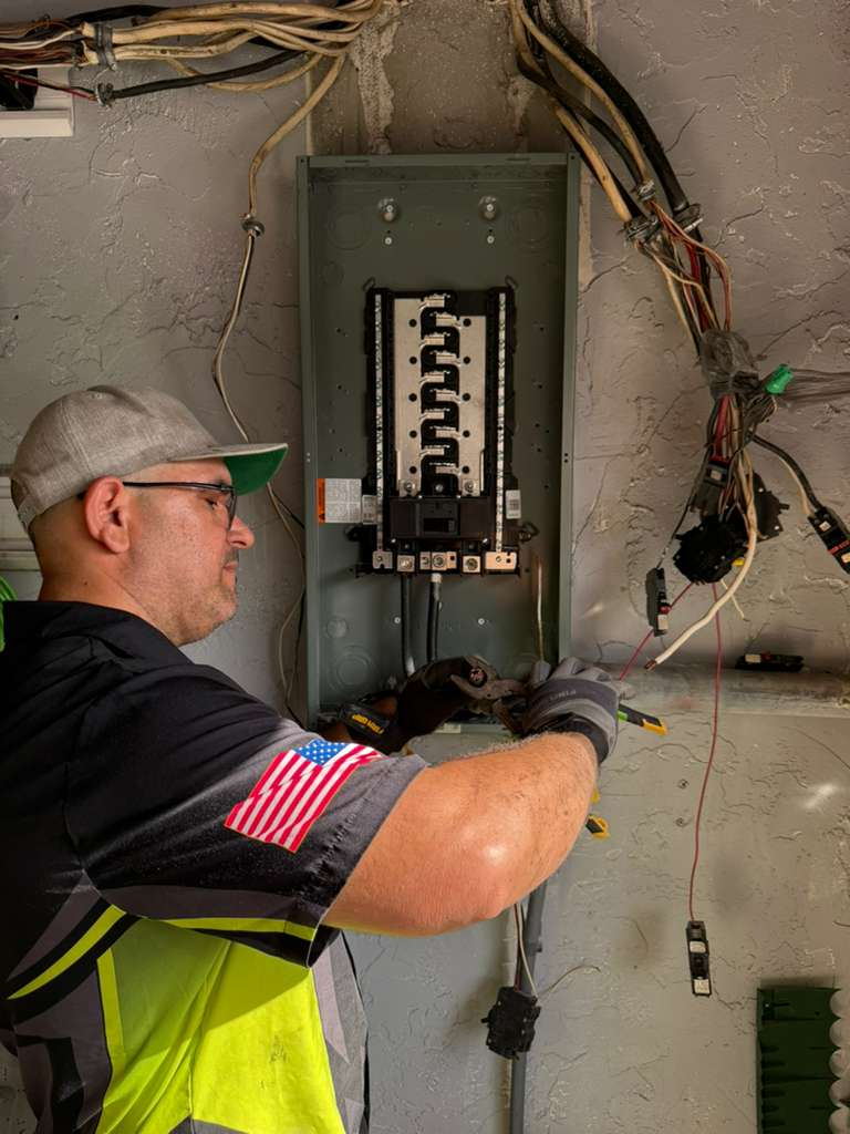 A man working on an electrical panel upgrade.