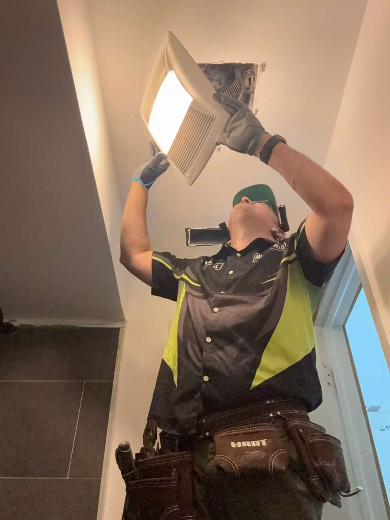 Electrician installing or repairing a ceiling light fixture/fan.