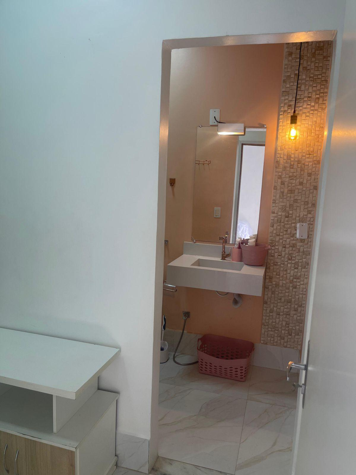 A newly remodeled bathroom with a modern sink, mirror, and decorative wall tiles. The floor has light-colored marble tiles, and there's a unique exposed light bulb fixture.
