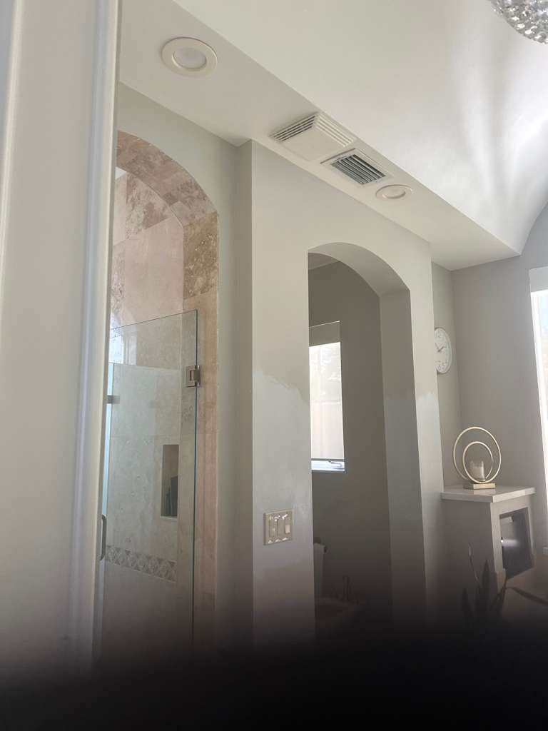 Master bathroom with arched openings and travertine shower