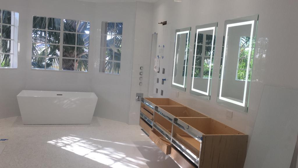 Luxury bathroom with LED mirrors and freestanding tub