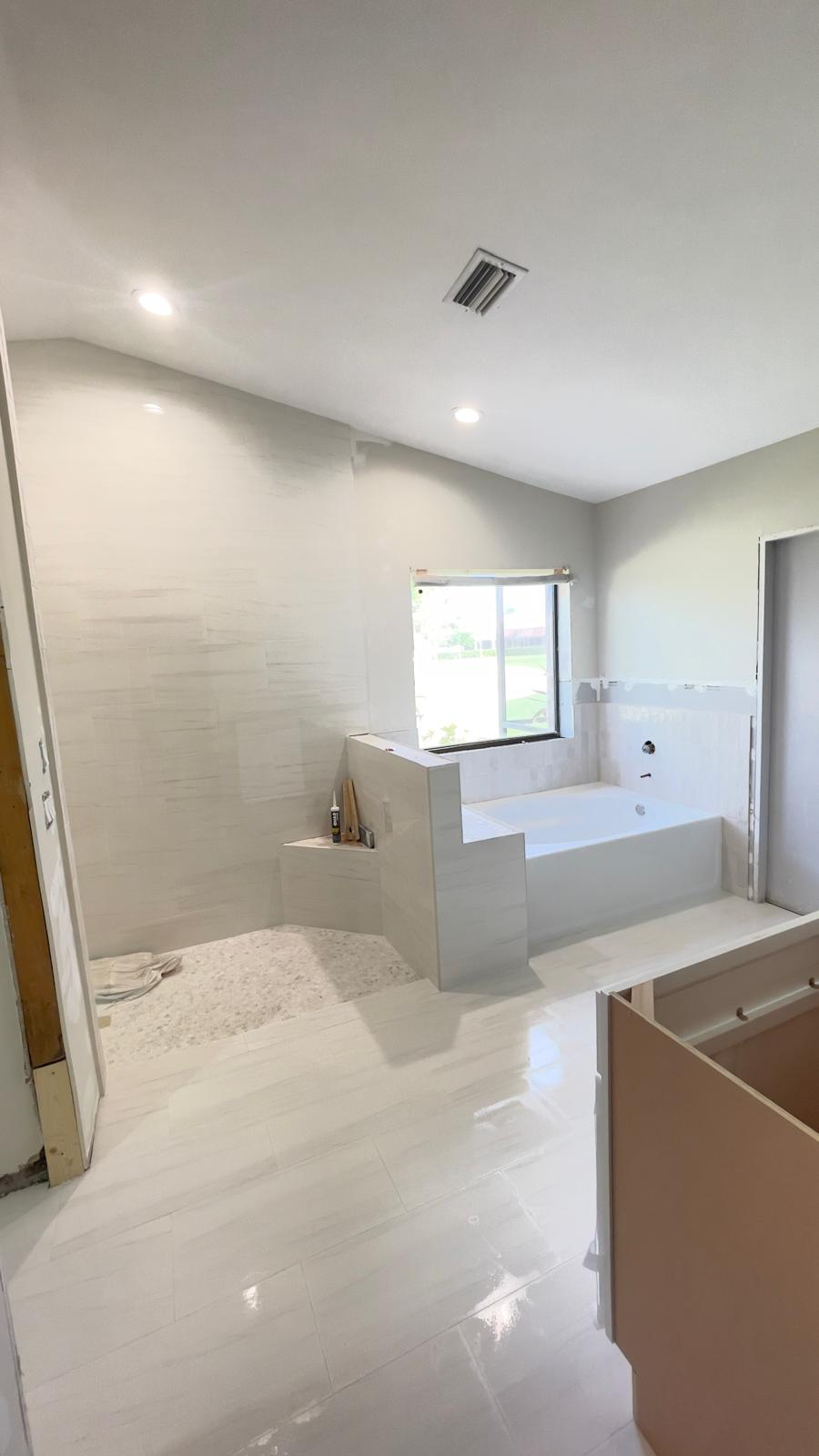 Bathroom renovation in progress with tub and shower